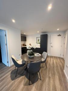 a living room with a dining room table and chairs at Stylish 2 bedroom modern apartment central to Eccles in Manchester
