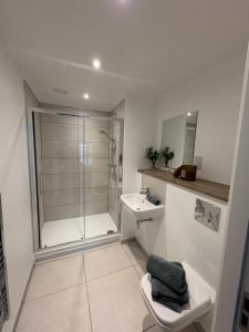 a bathroom with a shower and a toilet and a sink at Stylish 2 bedroom modern apartment central to Eccles in Manchester