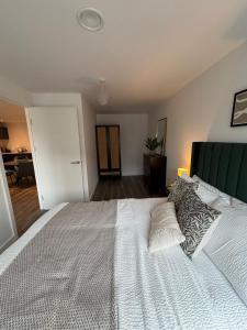 a bedroom with a large white bed with pillows at Stylish 2 bedroom modern apartment central to Eccles in Manchester
