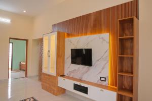 a living room with a tv on a wall at MK service apartment in Tirunelveli