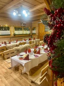 a restaurant with tables and chairs and a christmas tree at Karczma Mikuda - Sauna Basen Jacuzzi z widokiem na góry - Kuligi - Parking in Zakopane
