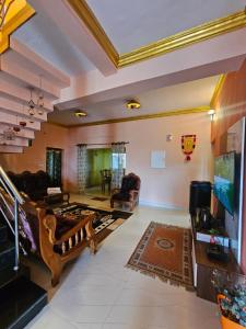a living room with a large tv and a couch at Kalon Elpis Villa in Ooty