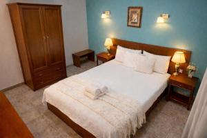 a bedroom with a large bed with a white blanket at Πανθεον in Kamena Vourla