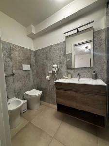 a bathroom with a sink and a toilet and a mirror at I due archi in Norcia