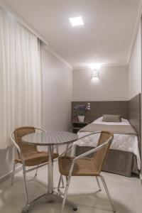a bedroom with a bed and a table and chairs at Hotel Gumz in Balneário Camboriú +110 photos