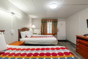 a hotel room with a bed and a dresser and a bed sidx sidx sidx at Attleboro Motor Inn in South Attleboro