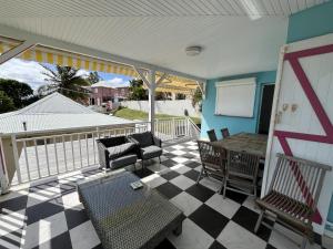 a screened in porch with a table and chairs at Maison Belle Vue in Le Robert