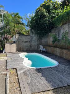 a small swimming pool with a bench in a yard at Maison Belle Vue in Le Robert