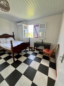 a bedroom with a black and white checkered floor at Maison Belle Vue in Le Robert +6 photos
