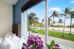 a bedroom with a large window looking out at the beach at Starlite Hotel in Miami Beach