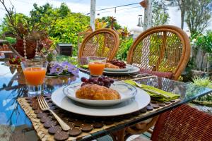 a table with two plates of food and orange juice at Hale Kawehi B&B Guesthouse in Hilo