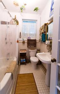 a bathroom with a toilet and a tub and a sink at Hale Kawehi Guesthouse in Hilo