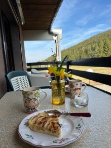 a plate of food on a table with coffee cups at Le Charme du Gaschney in Muhlbach-sur-Munster
