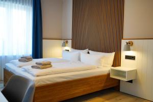a bedroom with a bed with towels on it at Hotel Seebrise Grömitz in Grömitz
