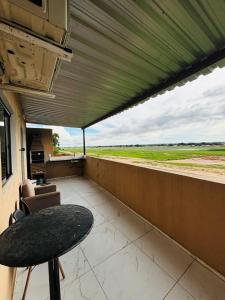 a balcony with a table and a view of a field at Flats Sucesso in Teresina