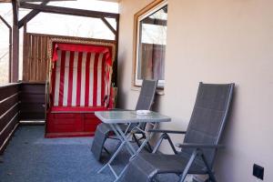 two chairs and a table in a room with a red door at Hotel Seebrise Grömitz in Grömitz