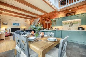 a kitchen and dining room with a wooden table and chairs at 3 Bed in Little Petherick oc-maplod in Little Petherick