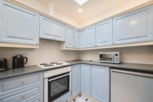 a white kitchen with white cabinets and a microwave at 2 Bed in Seahouses oc-nb1974 in North Sunderland