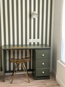 a desk with a chair next to a striped wall at Hotel Eden in Saint Malo