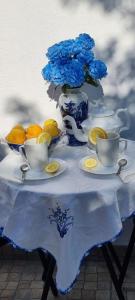 a table with a vase with blue flowers and lemons at Vivenda Silva in Santo António da Charneca