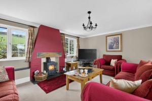 a living room with red furniture and a fireplace at 3 Bed in Braunton oc-ashb in Braunton