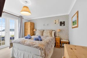 a bedroom with a large bed with blue pillows on it at 3 Bed in Braunton oc-ashb in Braunton