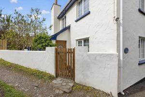 a white house with a wooden fence next to it at 3 Bed in Braunton oc-ashb in Braunton