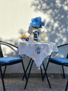 a table with a vase with blue flowers on it at Vivenda Silva in Santo António da Charneca