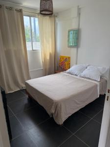 a bedroom with a bed in a room with a window at Chez Charline in Saint-Claude