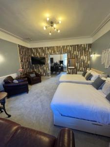 a large bedroom with two beds and a living room at Clifton Villa Guest House in Llandudno