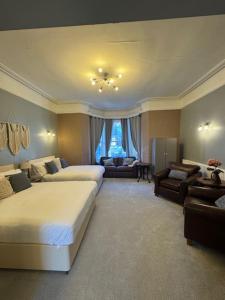 a large bedroom with two beds and a living room at Clifton Villa Guest House in Llandudno