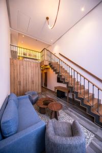 a living room with a blue couch and chairs and stairs at Taghazout Palm Hotel in Taghazout