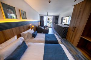 a hotel room with a large bed and a couch at Taghazout Palm Hotel in Taghazout