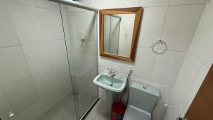 a bathroom with a sink and a toilet and a mirror at Caminho de Itacoatiara in Niterói