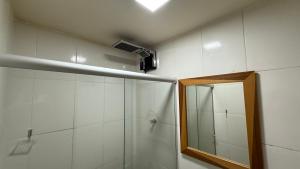 a bathroom with a shower and a mirror at Caminho de Itacoatiara in Niterói