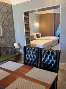 a room with two beds and a chair and a mirror at The Gwydir Ground Floor Studio in Llandudno