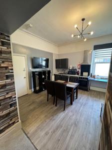 a living room with a table and a kitchen at The Gwydir Ground Floor Studio in Llandudno +4 photos