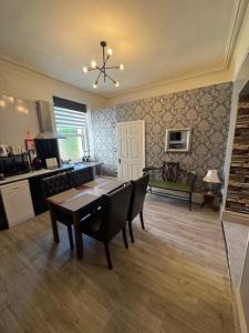 a living room with a table and a kitchen at The Gwydir Ground Floor Studio in Llandudno
