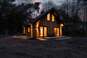 a small wooden house with windows at night at Casa Allocco in Norg