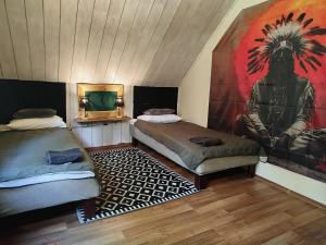 a room with two beds and a painting on the wall at Wilcze Schronisko in Czerniki