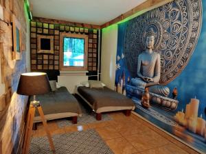 a room with two beds and a mural of a buddha at Wilcze Schronisko in Czerniki