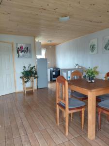 a kitchen and dining room with a table and chairs at Cabaña Aeropuerto el Tepual in Puerto Montt