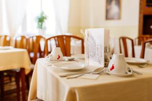 a table with plates and utensils on top of it at Boutique Hotel Nossek in Vienna