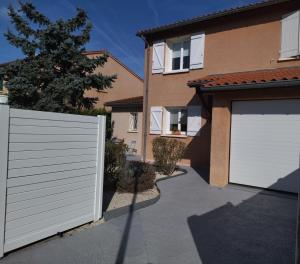 a house with white garage doors and a driveway at Fleurs de Cosmos, suite lumineuse climatisée in Albi