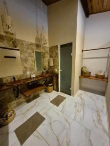 a large bathroom with a marble floor and a mirror at Biruta's Beach House - Taíba in São Gonçalo do Amarante