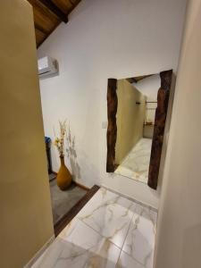 a room with a mirror and a vase on the floor at Biruta's Beach House - Taíba in São Gonçalo do Amarante