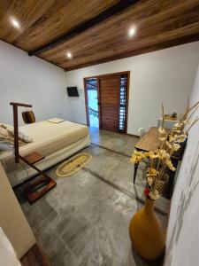 a bedroom with a bed and a table in a room at Biruta's Beach House - Taíba in São Gonçalo do Amarante