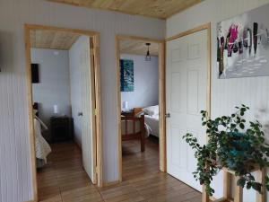a hallway with a door open to a bedroom at Cabaña Aeropuerto el Tepual in Puerto Montt