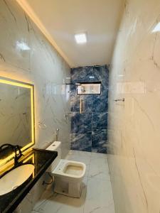a bathroom with a toilet and a sink and a mirror at Flats Sucesso in Teresina +12 photos