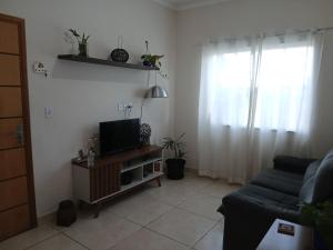 a living room with a tv and a couch at Quarto Rustico em Alfenas in Alfenas